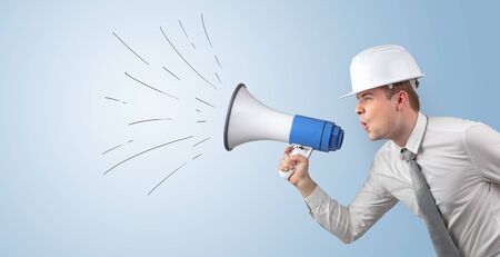 Young architect constructor yelling with megaphone and copyspaceの写真素材
