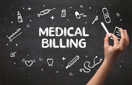 Hand drawing MEDICAL BILLING inscription with white chalk on blackboard, medical conceptの写真素材