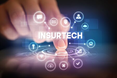 Finger touching tablet with web technology icons and INSURTECH inscription, web technology conceptの写真素材