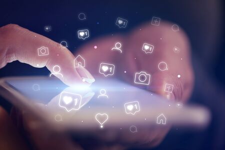 Finger touching phone with social media concept and dark backgroundの写真素材