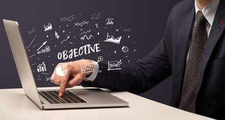Businessman working on laptop with OBJECTIVE  inscription, modern business conceptの写真素材