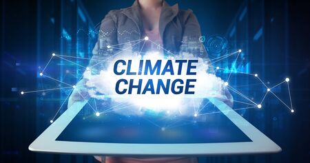 Young business person working on tablet and shows the inscription: CLIMATE CHANGEの写真素材