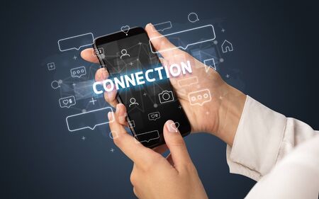 Female hand typing on smartphone with CONNECTION inscription, social media conceptの写真素材