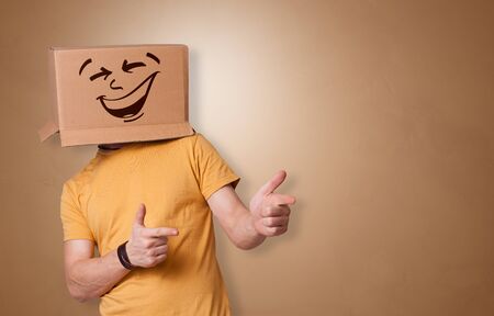Young boy standing and gesturing with a cardboard box on his head
の写真素材