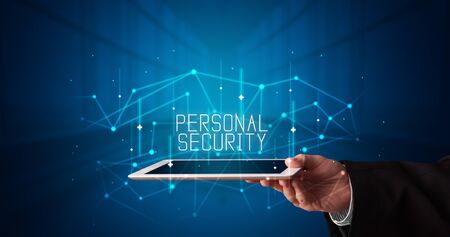 Young business person working on tablet and shows the digital sign: PERSONAL SECURITYの写真素材