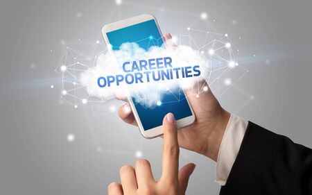 Female hand touching smartphone with CAREER OPPORTUNITIES inscription, cloud business conceptの写真素材