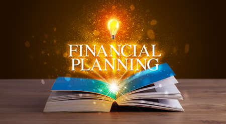 FINANCIAL PLANNING inscription coming out from an open book, educational conceptの写真素材