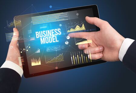 Close-up of hands holding tablet with BUSINESS MODEL inscription, modern business conceptの写真素材