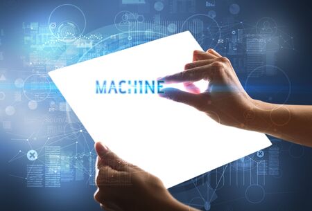Hand holdig futuristic tablet with MACHINE  inscription, new technology conceptの写真素材