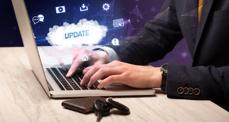 Businessman working on laptop with UPDATE inscription, modern technology conceptの写真素材