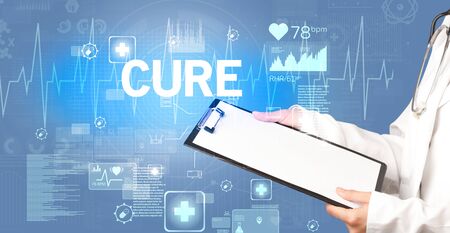young doctor writing down notes with CURE inscription, healthcare conceptの写真素材