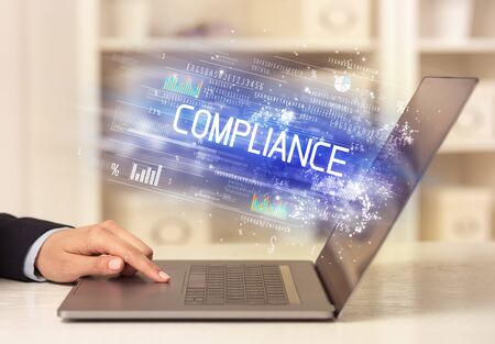 Closeup of businessman hands working on laptop with COMPLIANCE  inscription, succesfull business conceptの写真素材