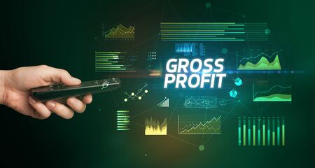 hand holding wireless peripheral with GROSS PROFIT inscription, cyber business conceptの写真素材
