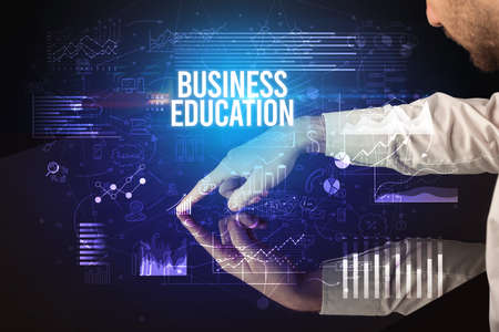 Businessman touching huge screen with BUSINESS EDUCATION inscription, cyber business conceptの写真素材