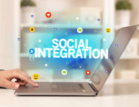 Freelance woman using laptop with SOCIAL INTEGRATION inscription, Social media conceptの写真素材
