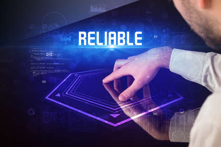 Hand touching digital table with RELIABLE inscription, new age security conceptの写真素材