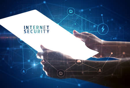 Holding futuristic tablet with INTERNET SECURITY inscription, cyber security conceptの写真素材