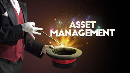 Illusionist is showing magic trick with ASSET MANAGEMENT inscription, new business model conceptの写真素材