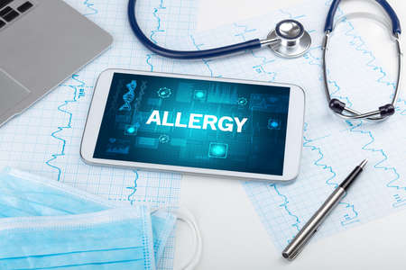 Tablet pc and medical stuff with ALLERGY  inscription, prevention concept