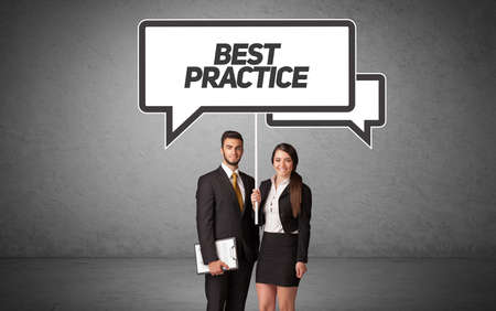 Young business person in casual holding road sign with BEST PRACTICE inscription, new business idea conceptの写真素材