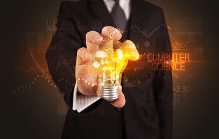 Businessman holding lightbulb with COMPUTER SCIENCE inscription, Business technology conceptの写真素材