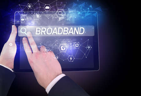 Close-up of a tablet searching BROADBAND inscription, hi-tech computing concept