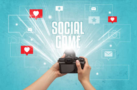 Close-up of a hand taking photos with SOCIAL GAME inscription, social media conceptの写真素材