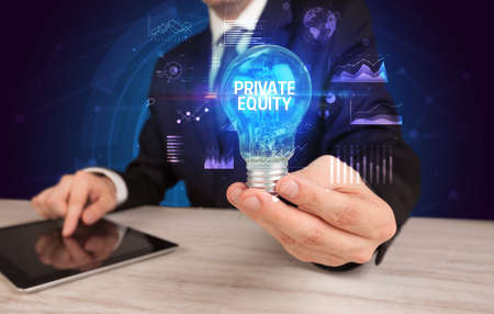 Businessman holding lightbulb with PRIVATE EQUITY inscription, Business idea conceptの写真素材