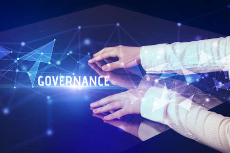 Businessman touching huge screen with GOVERNANCE inscription, modern technology business conceptの写真素材