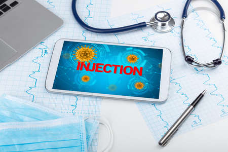 Close-up view of a tablet pc with INJECTION inscription, microbiology concept
