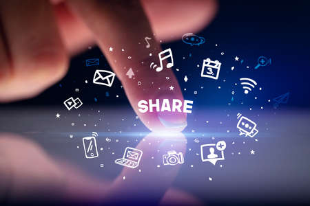 Finger touching tablet with drawn social media icons and SHARE inscription, social networking conceptの写真素材
