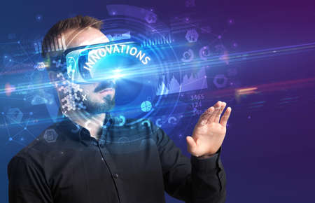 Businessman looking through Virtual Reality glasses with INNOVATIONS inscription, innovative...