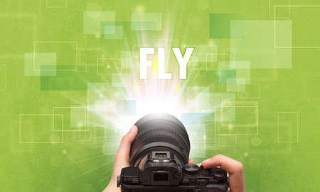 Close-up of a hand holding digital camera with FLY inscription, traveling concept
