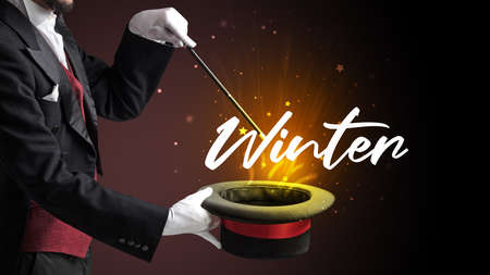 Magician is showing magic trick with Winter inscription, traveling conceptの写真素材