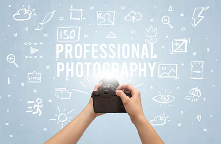 Hand taking picture with digital camera and PROFESSIONAL PHOTOGRAPHY inscription, camera settings conceptの写真素材