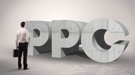 Rear view of a businessman standing in front of PPC abbreviation, modern technology conceptの写真素材
