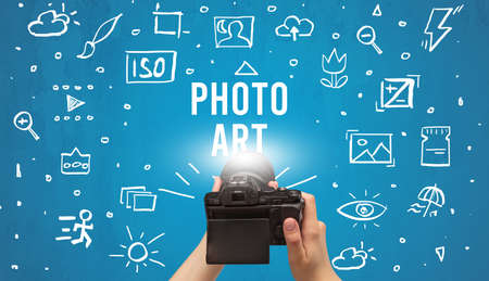 Hand taking picture with digital camera and PHOTO ART inscription, camera settings conceptの写真素材