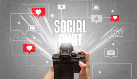 Close-up of a hand taking photos with SOCIAL CHAT inscription, social media concept