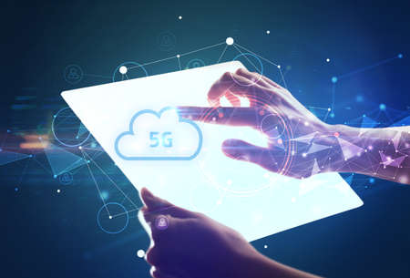 Hand holdig futuristic tablet with 5G inscription, modern technology conceptの写真素材