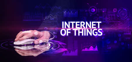 hand holding wireless peripheral with INTERNET OF THINGS inscription, modern technology conceptの写真素材