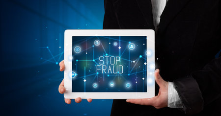 Young business person working on tablet and shows the digital sign: STOP FRAUDの写真素材