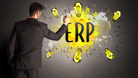 businessman drawing colorful light bulb with ERP abbreviation, new technology idea conceptの写真素材