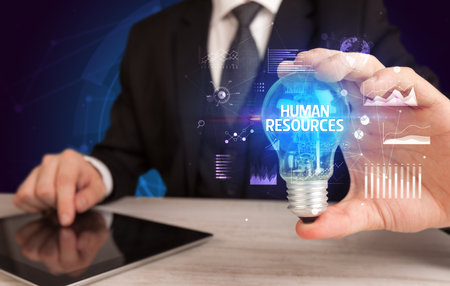 Businessman holding lightbulb with HUMAN RESOURCES inscription, Business idea conceptの写真素材