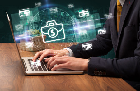 business hand working in stock market with briefcase icons coming out from laptop screenの写真素材