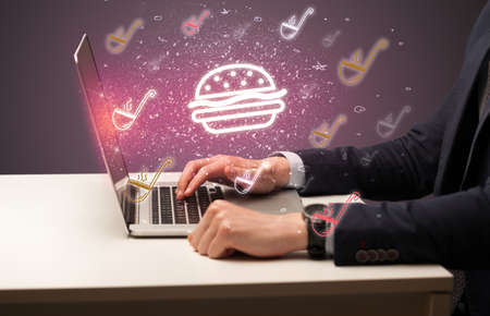 Hand searching for recipes on the internet with chef icons coming out from the screenの写真素材