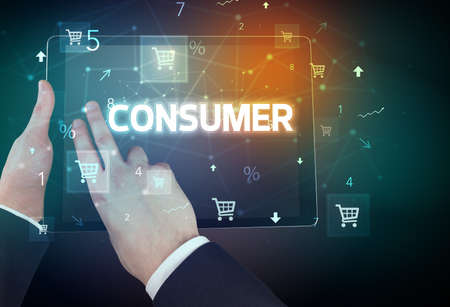 Close-up of a hand holding tablet with CONSUMER inscription, online shopping conceptの写真素材