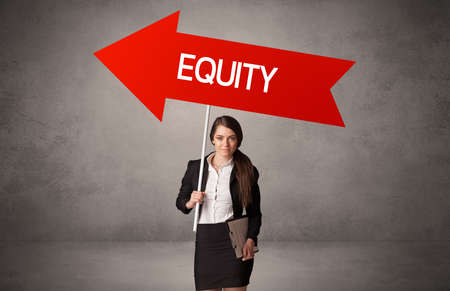 Young business person in casual holding road signの写真素材