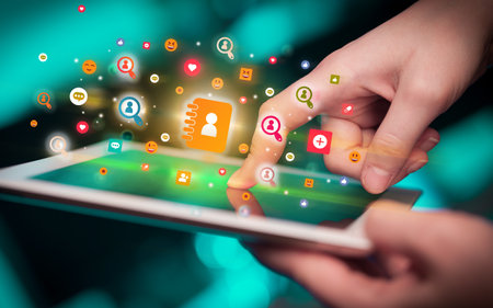 Close-up of a hand using tablet with social media icons