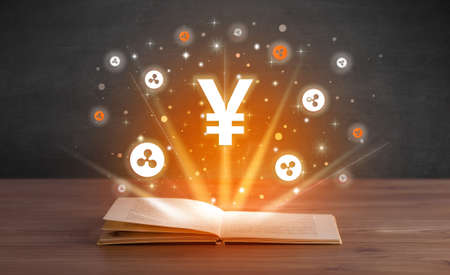 Open book with currency icons aboveの写真素材