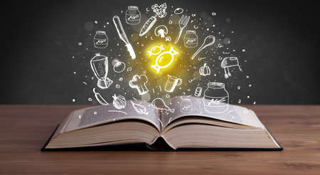 Open recipe book with food related icons aboveの写真素材